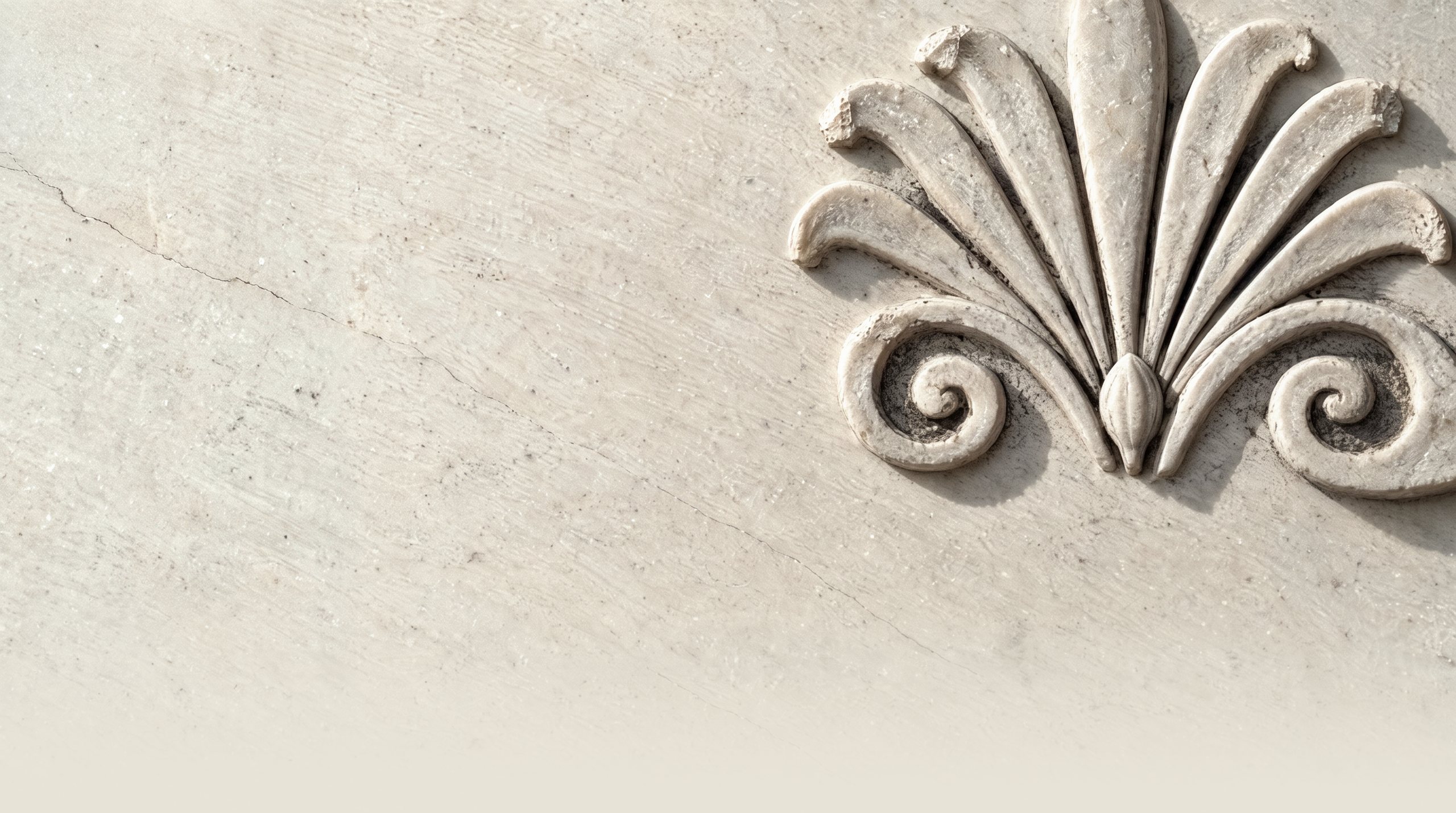A carved marble anthemion under raking light